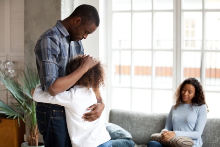 girl hugging dad with mom in background